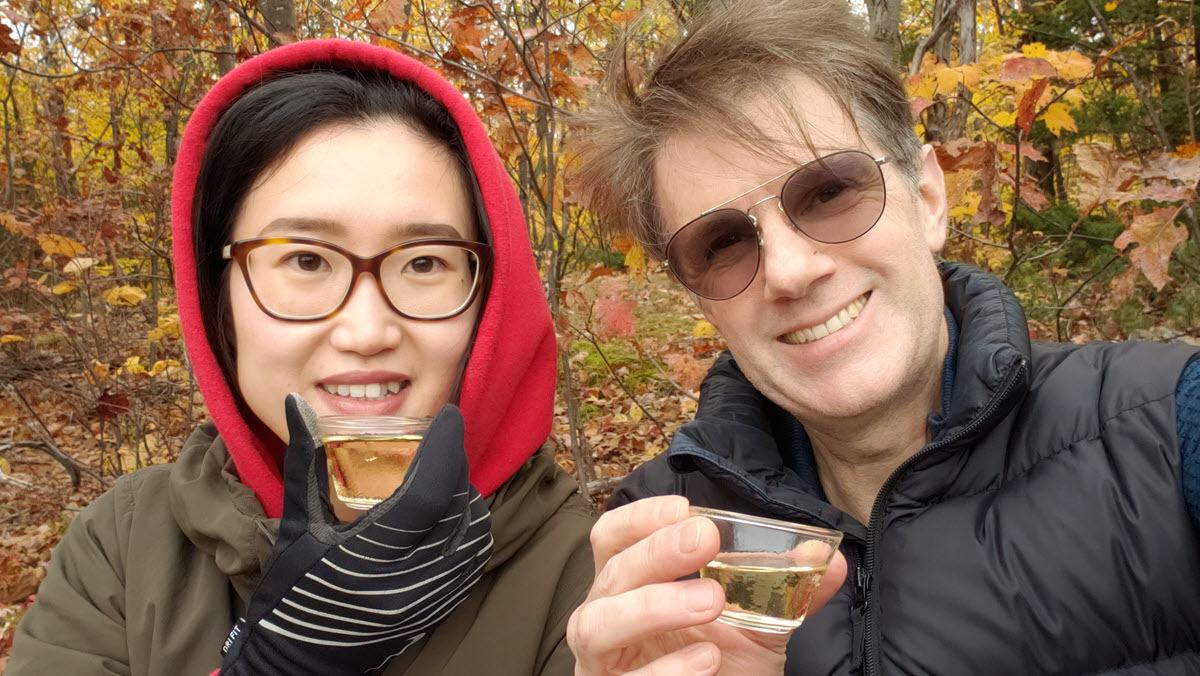 Zhen Lu and Phil Rushworth sipping tea in the forest