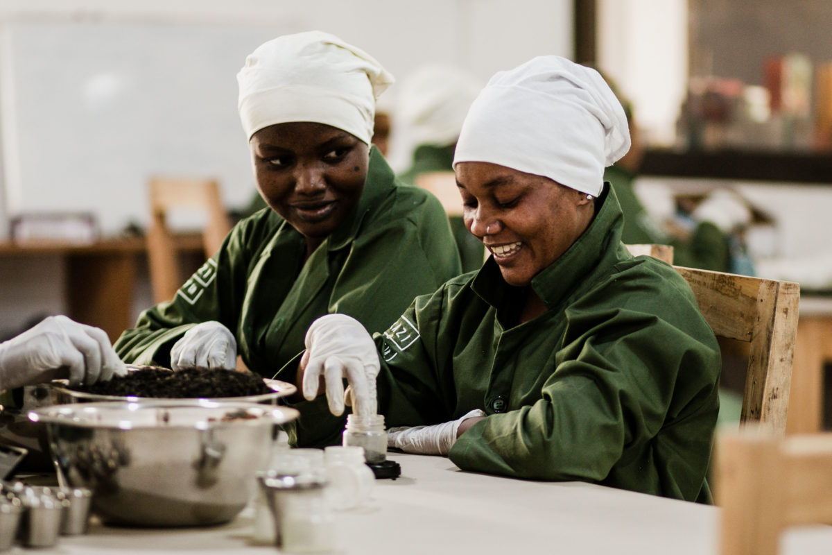 Two women pack tea at Kazi Yetu's factory in Tanzania.